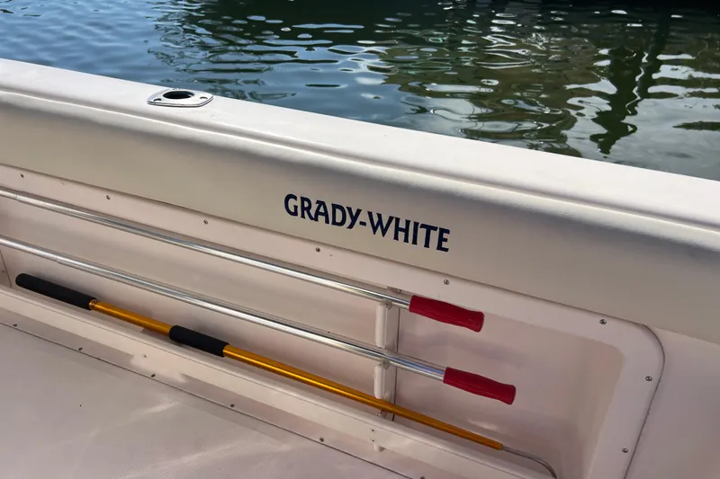 Slide: The Image of 1999 Grady-White Escape 209 boat interior with oars, docked on calm water. - 19