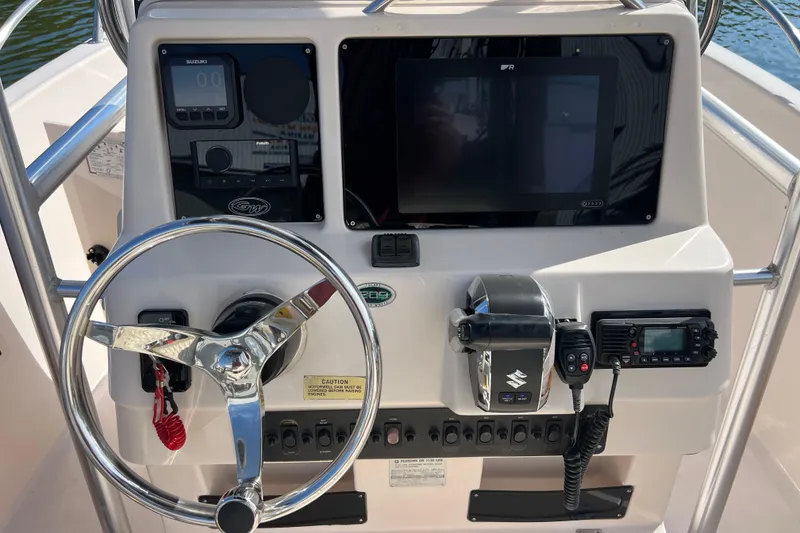 Slide: The Image of 1999 Grady-White Escape 209 boat dashboard with steering wheel and control panel. - 20