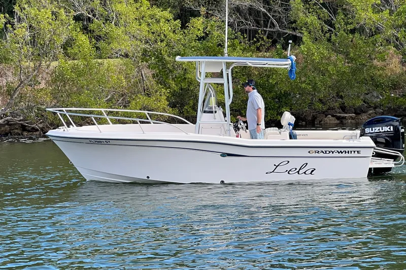 Slide: The Image of 1999 Grady-White Escape 209 boat on water, with trees in the background. - 3