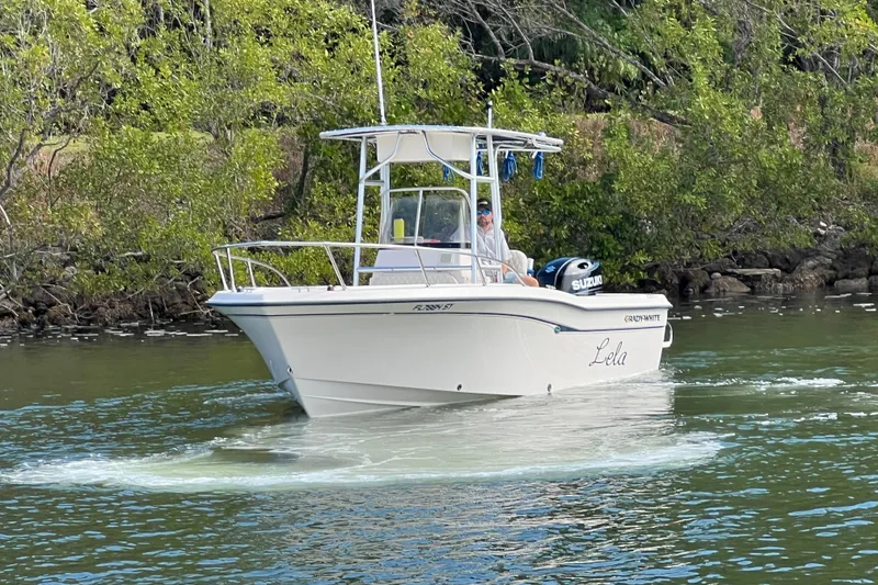 Slide: The Image of 1999 Grady-White Escape 209 boat cruising on a calm river near lush greenery. - 5