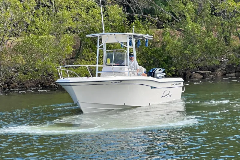 Slide: The Image of 1999 Grady-White Escape 209 boat on water, surrounded by lush greenery. - 6
