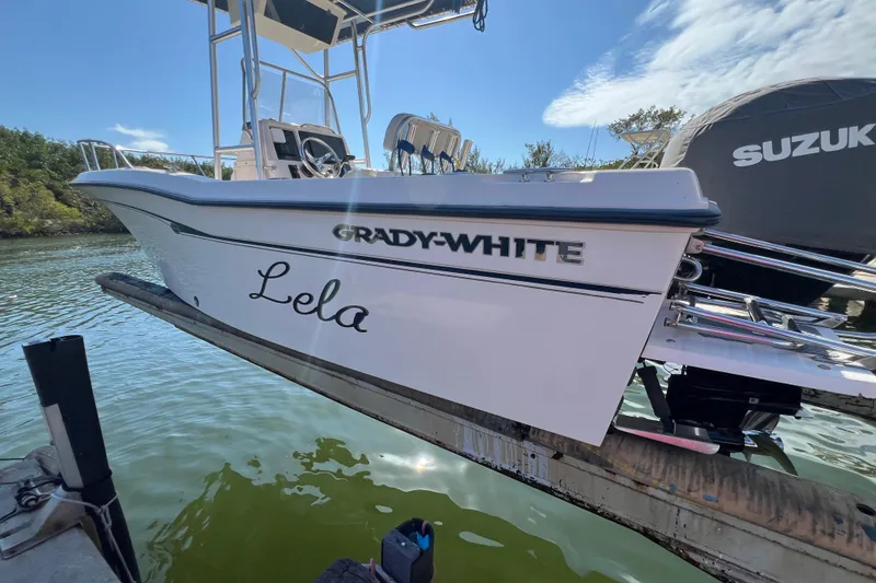 Slide: The Image of 1999 Grady-White Escape 209 boat named "Lela" on a lift, with Suzuki engine. - 8
