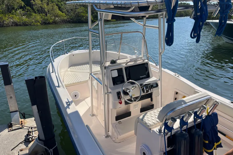 Slide: The Image of 1999 Grady-White Escape 209 boat docked on calm water, featuring a central console. - 9