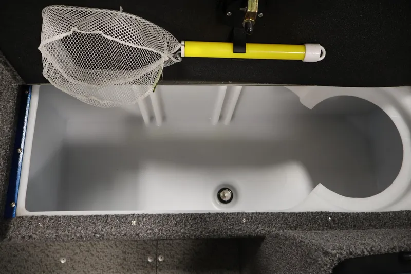 Slide: The Image of 2021 Lund 1650 Angler Sport boat interior with fishing net and storage compartment. - 15