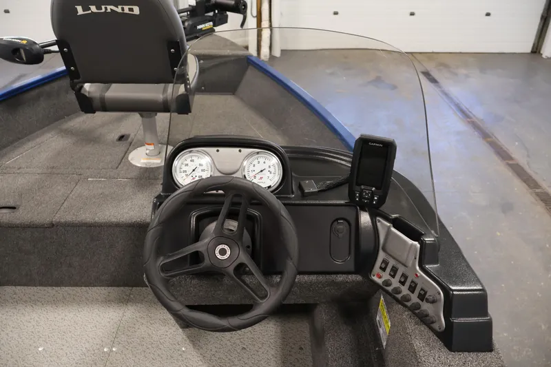 Slide: The Image of 2021 Lund 1650 Angler Sport boat interior with steering wheel and dashboard controls. - 17
