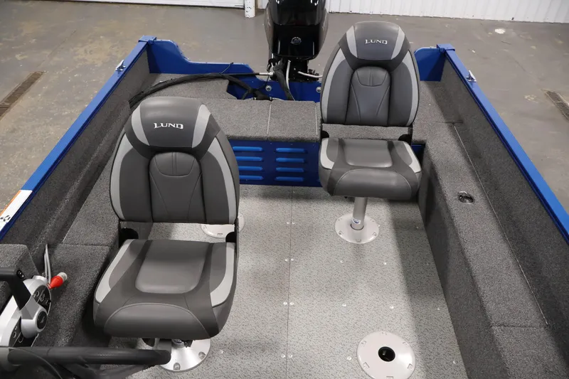Slide: The Image of 2021 Lund 1650 Angler Sport boat interior with two gray seats and steering console. - 23