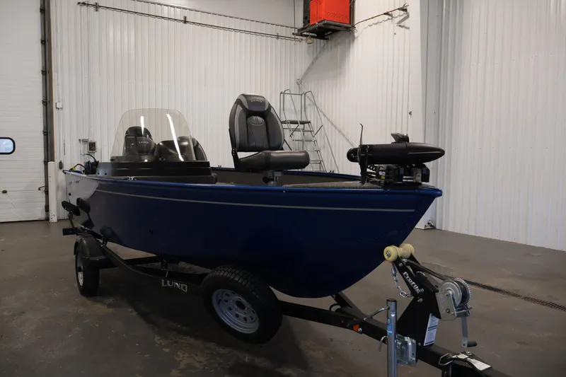 Slide: The Image of 2021 Lund 1650 Angler Sport boat in a garage, blue exterior, on a trailer. - 3