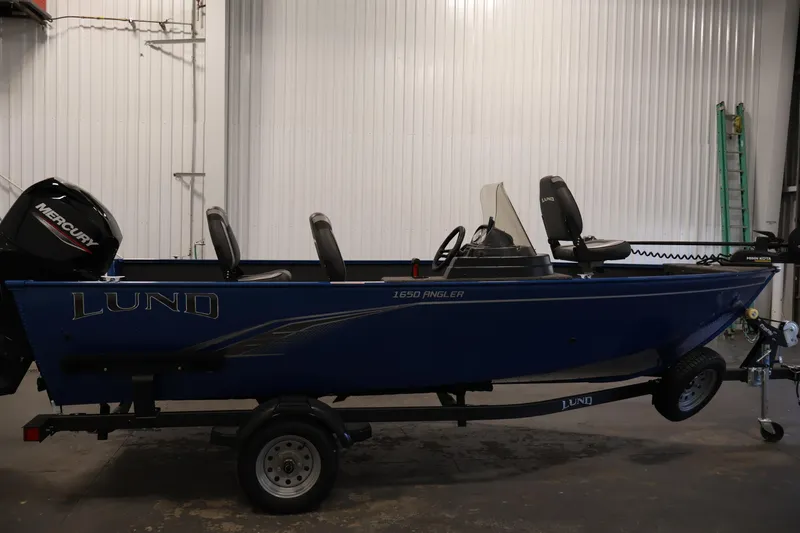 Slide: The Image of 2021 Lund 1650 Angler Sport boat with Mercury engine in a garage setting. - 4