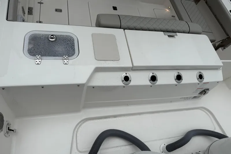 Slide: The Image of 2025 Pursuit OS 325 Offshore boat interior with storage compartments and rod holders. - 10