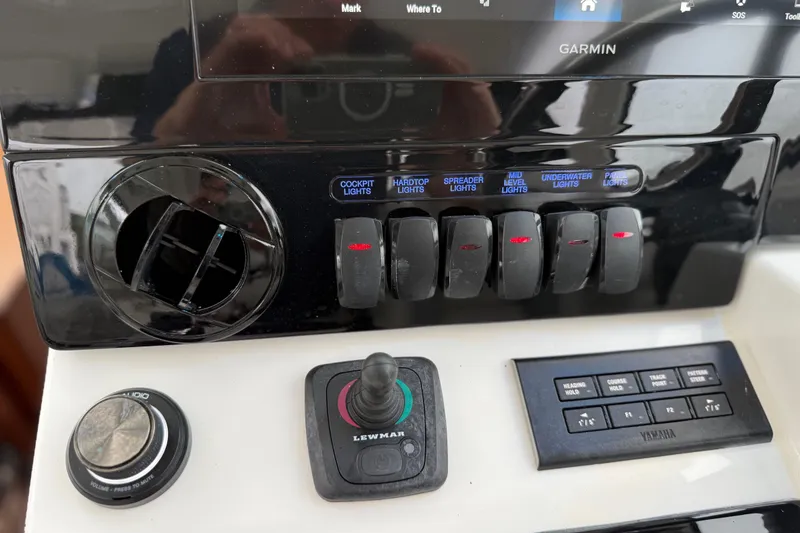 Slide: The Image of Control panel of 2025 Pursuit OS 325 Offshore boat with switches and navigation controls. - 48