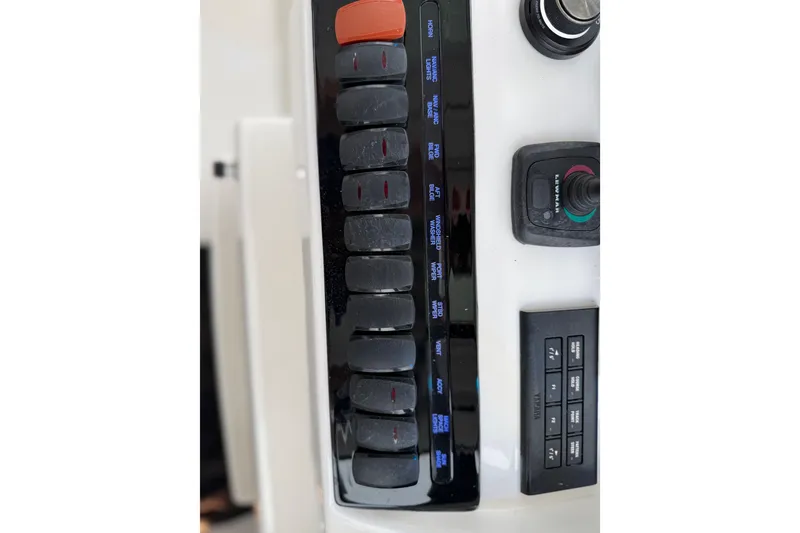 Slide: The Image of Control panel of 2025 Pursuit OS 325 Offshore boat with switches and joystick. - 50