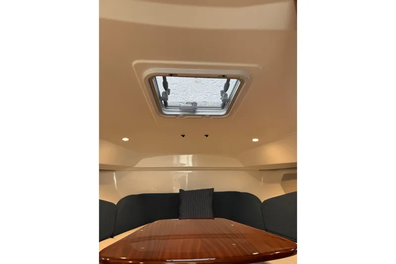 Slide: The Image of 2025 Pursuit OS 325 Offshore cabin interior with skylight and seating area. - 56