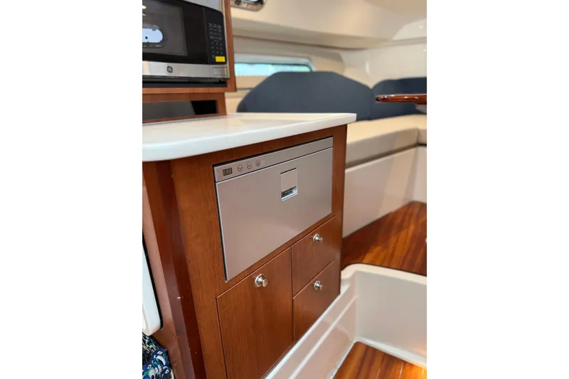 Slide: The Image of 2025 Pursuit OS 325 Offshore interior with microwave and wooden cabinetry. - 58