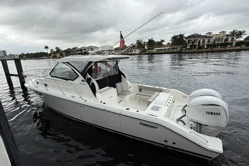 Slide: The Image of 2025 Pursuit OS 325 Offshore boat with Yamaha engines on a calm waterway. - 6