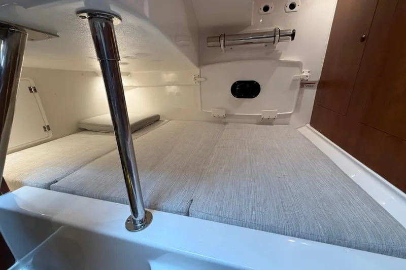 Slide: The Image of 2025 Pursuit OS 325 Offshore cabin interior with cushioned seating and storage compartments. - 62