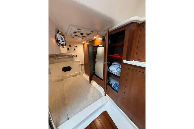 Slide: The Image of 2025 Pursuit OS 325 Offshore cabin interior with wood cabinetry and storage. - 64