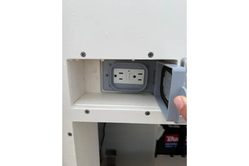 Slide: The Image of Electrical outlet with cover on 2025 Pursuit OS 325 Offshore boat. - 82