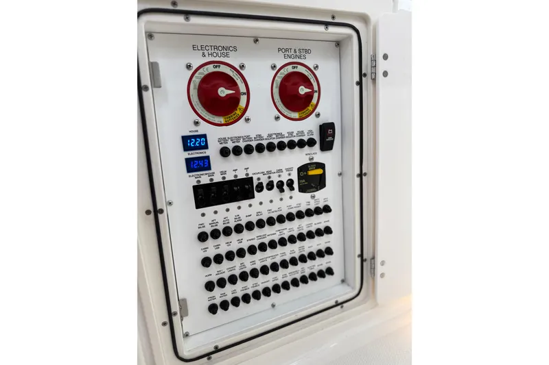 Slide: The Image of Electrical control panel of 2025 Pursuit OS 325 Offshore boat, featuring switches and voltage displays. - 83