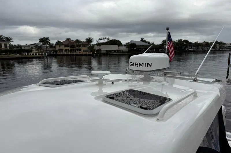 Slide: The Image of 2025 Pursuit OS 325 Offshore boat with Garmin radar on a cloudy waterfront. - 87