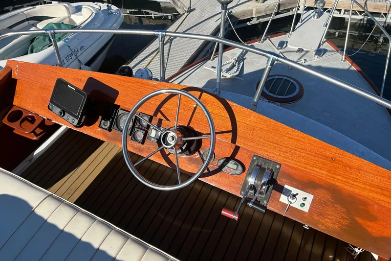 Slide: The Image of 1986 Skiff Craft Sport Fisherman boat helm with wooden dashboard and steering wheel. - 3