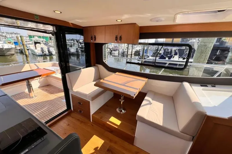 Slide: The Image of Interior of 2023 Pescador 35 boat with seating, table, and marina view. - 13