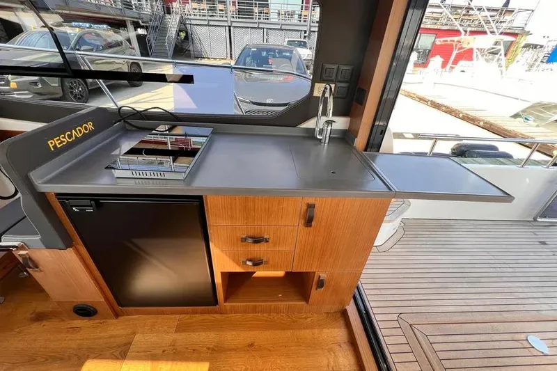 Slide: The Image of Modern kitchen area on 2023 Pescador 35 boat with sink, stove, and storage. - 15