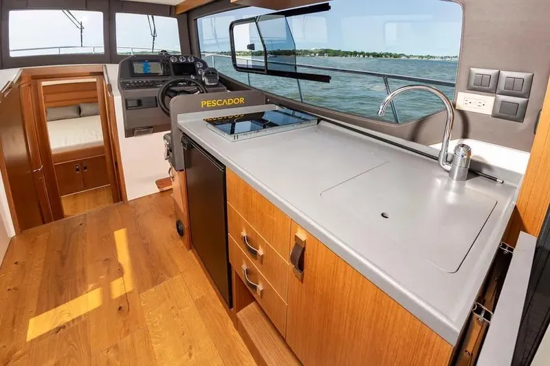Slide: The Image of Interior of 2023 Pescador 35 boat with modern kitchen and steering area. - 21