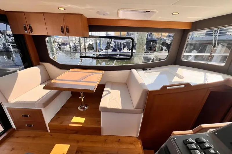 Slide: The Image of Interior of 2023 Pescador 35 boat with seating, table, and large windows. - 24