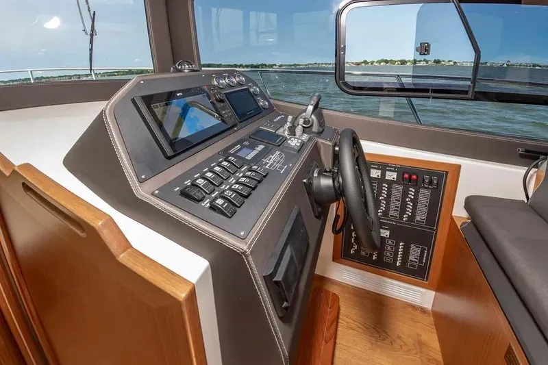 Slide: The Image of 2023 Pescador 35 boat cockpit with modern controls and scenic water view. - 26