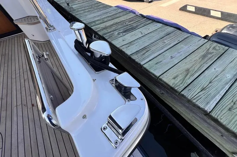 Slide: The Image of 2023 Pescador 35 yacht docked, showcasing sleek chrome fittings and wooden deck. - 7