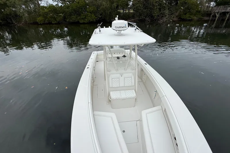 Slide: The Image of 2009 Jupiter 29 boat with Garmin equipment on calm water, surrounded by trees. - 10