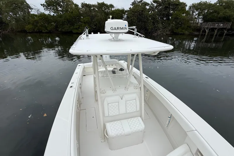 Slide: The Image of 2009 Jupiter 29 boat with Garmin equipment on calm water, surrounded by trees. - 11
