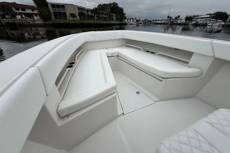 Slide: The Image of 2009 Jupiter 29 boat interior with white cushioned seating and storage compartments. - 13