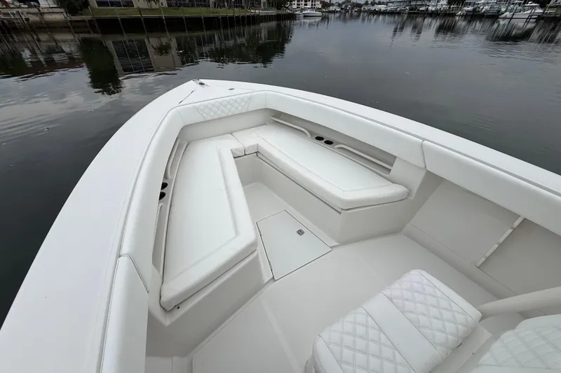 Slide: The Image of 2009 Jupiter 29 boat with white cushioned seating, docked on calm water. - 15