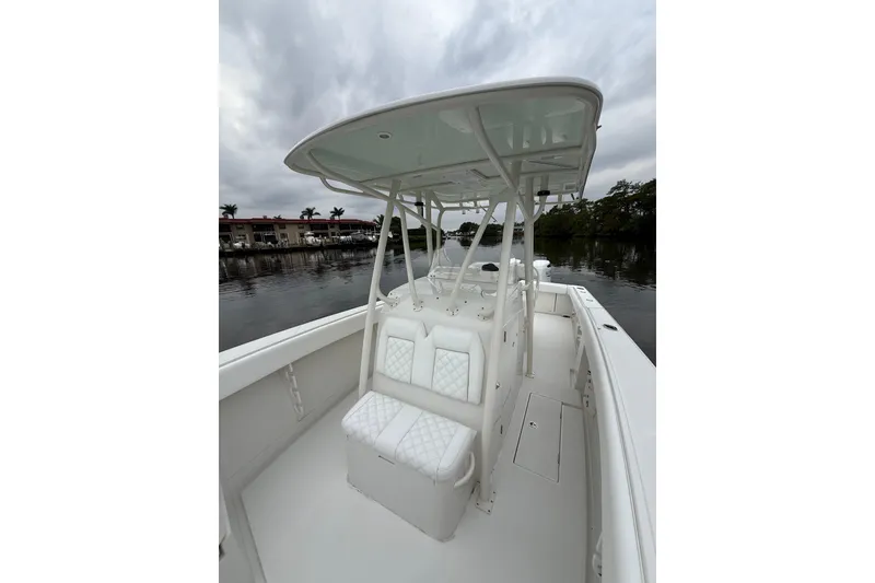 Slide: The Image of 2009 Jupiter 29 boat with white seating and canopy on a calm waterway. - 16
