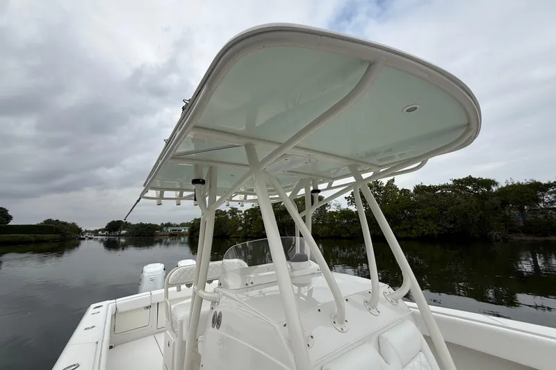 Slide: The Image of 2009 Jupiter 29 boat with T-top, docked on a calm river under cloudy skies. - 19