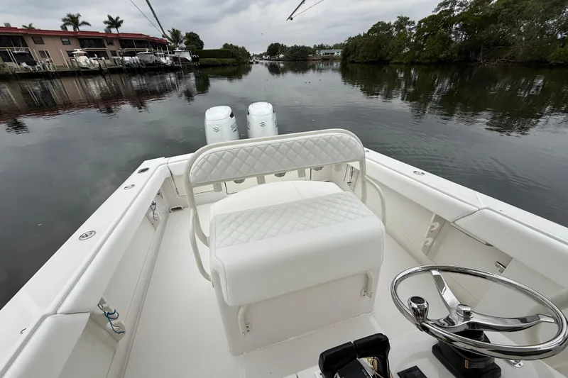 Slide: The Image of 2009 Jupiter 29 boat interior with white seating, steering wheel, and calm waterfront view. - 22