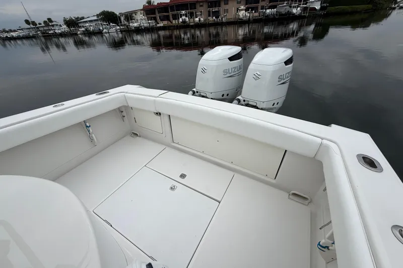 Slide: The Image of 2009 Jupiter 29 boat with twin Suzuki outboard engines docked by calm waters. - 27