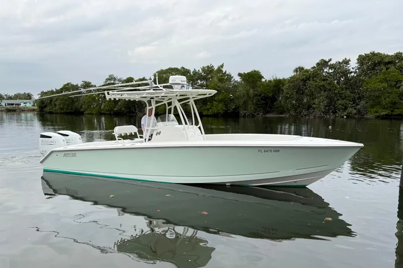 Slide: The Image of 2009 Jupiter 29 boat on calm water, featuring Suzuki engines and lush green shoreline. - 3