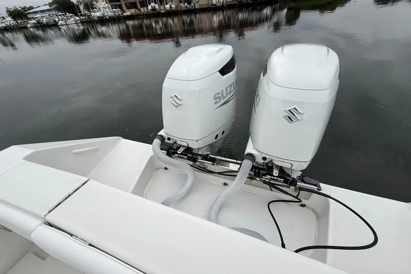 Slide: The Image of Twin Suzuki outboard motors on a 2009 Jupiter 29 boat, docked by calm waters. - 30
