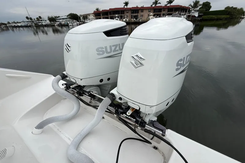 Slide: The Image of Twin Suzuki outboard motors on a 2009 Jupiter 29 boat, docked by calm waters. - 31