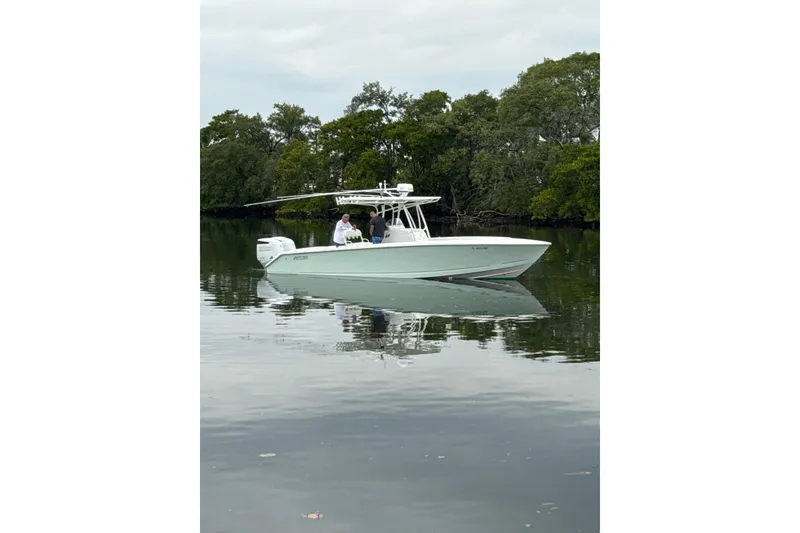 Slide: The Image of 2009 Jupiter 29 boat on calm water with lush green trees in the background. - 38