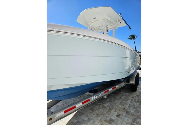 Slide: The Image of 2017 Robalo R242 Center Console boat on trailer, sunny day, palm tree background. - 13