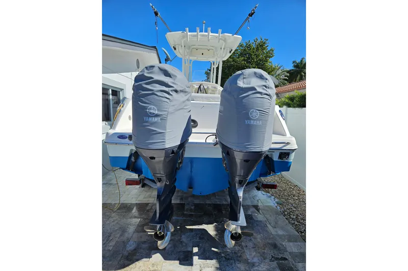 Slide: The Image of 2017 Robalo R242 Center Console with twin Yamaha outboard motors, covered and parked outdoors. - 15