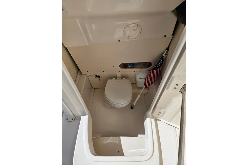 Slide: The Image of 2017 Robalo R242 Center Console boat interior with compact marine toilet. - 22