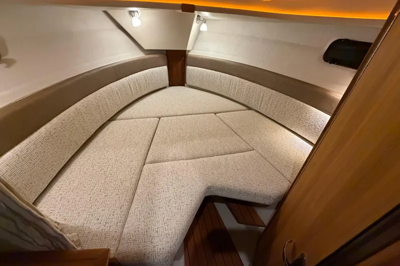 Slide: The Image of 2023 Ranger Tugs R-27 interior cabin with cozy seating and ambient lighting. - 12