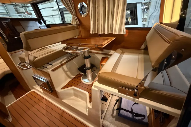 Slide: The Image of 2023 Ranger Tugs R-27 interior with seating, table, and wood flooring. - 13