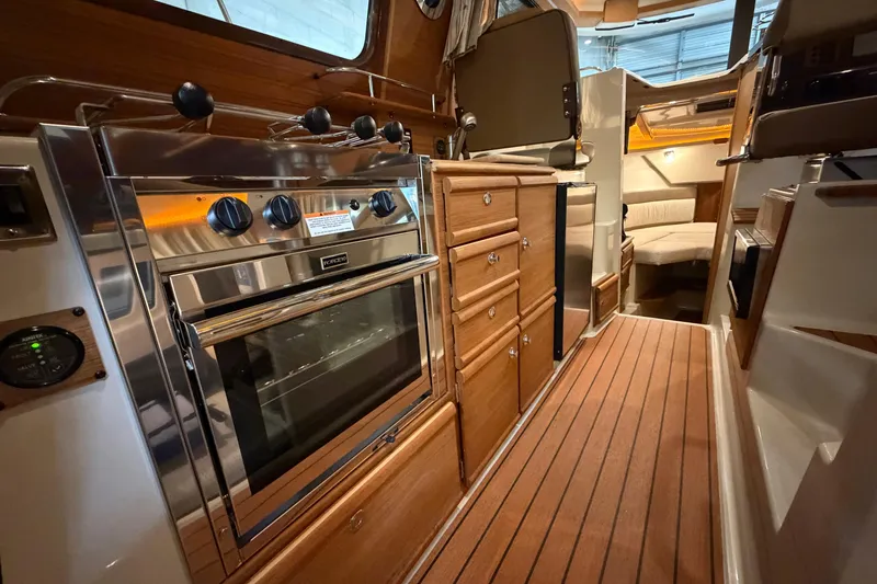 Slide: The Image of 2023 Ranger Tugs R-27 interior with modern kitchen and cozy seating area. - 18
