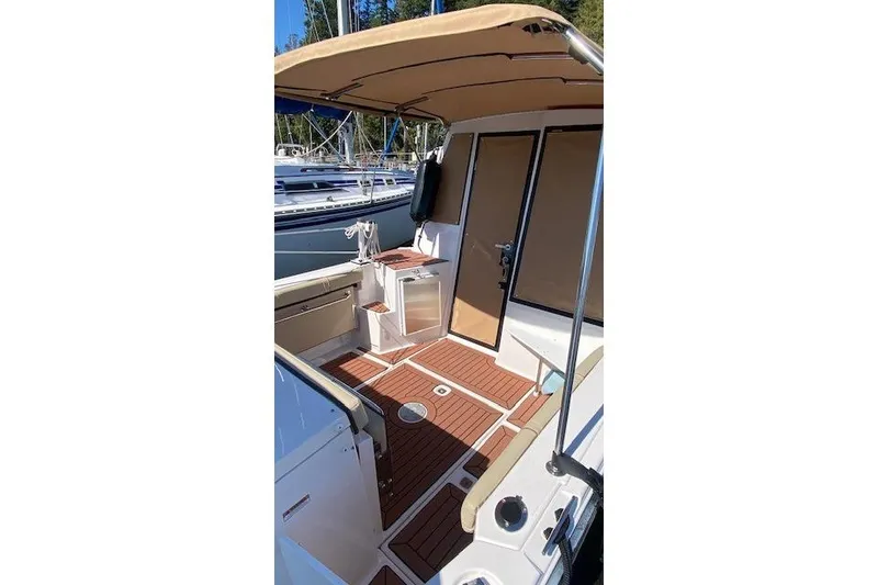 Slide: The Image of 2023 Ranger Tugs R-27 boat interior with teak flooring and canopy. - 4
