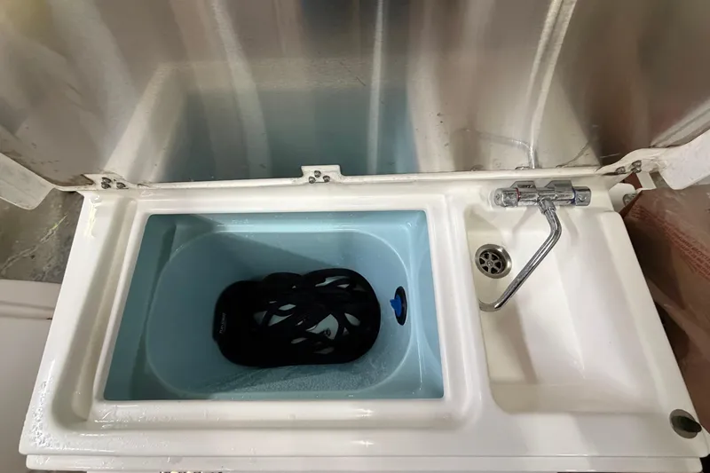 Slide: The Image of 2023 Ranger Tugs R-27 boat sink with faucet and black object inside. - 7